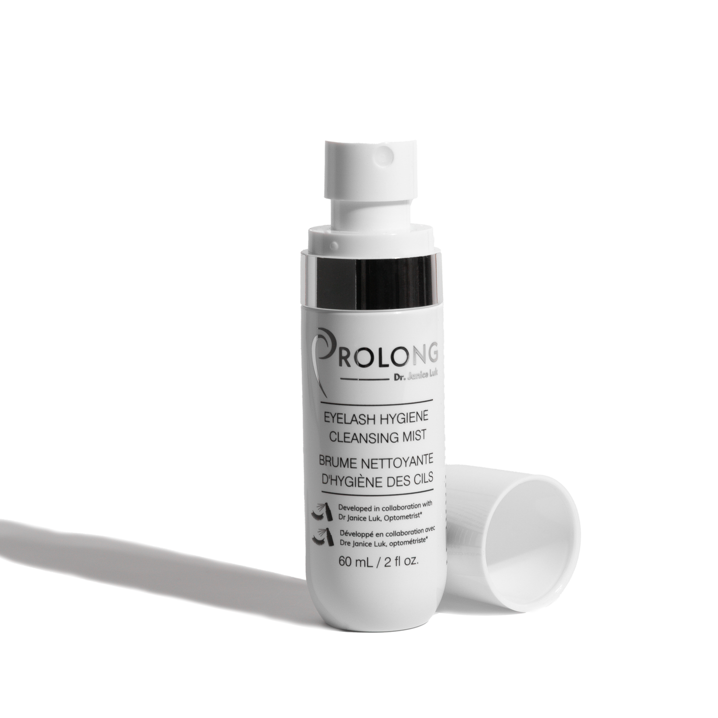 A white bottle of Prolong by Dr. Janice Luk Eyelash Hygiene Cleansing Mist with its cap lying beside it on a clean white background.