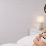 A lash artist checking their clients comfort prior to application