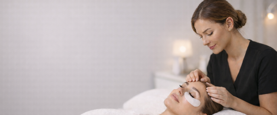 A lash artist checking their clients comfort prior to application